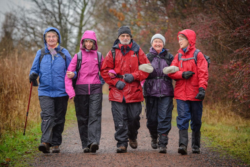 Five people walking in wet weather clothing